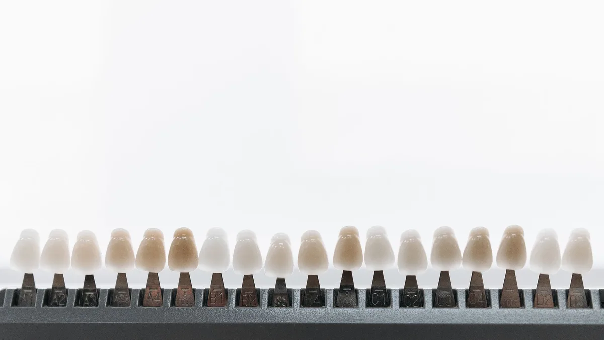 Close-up view of dental veneers on a display rack, showcasing various shades.