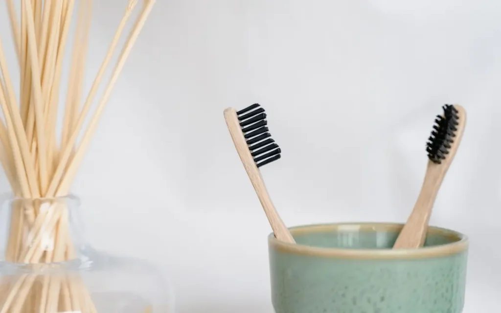 Dwie bambusowe szczoteczki do zębów w ceramicznym kubku
