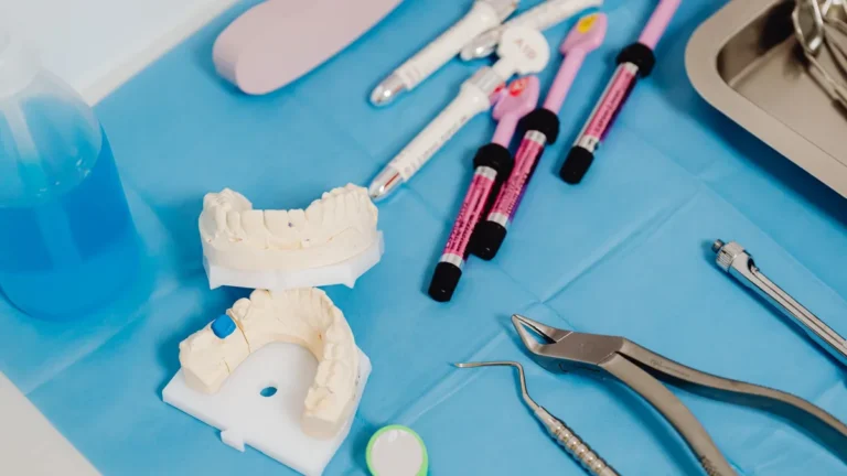 Close-up of dental instruments and tooth models on a clinic table for dental care procedures.